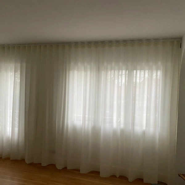 Voilages blancs sur fenêtre, plis souples